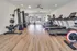 Modern fitness center with state-of-the-art equipment, including treadmills, weight machines, and a bench press, offering a bright and motivating workout environment.