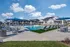 Inviting apartment community featuring a luxurious pool area with sun loungers, umbrellas, and modern outdoor seating under a clear blue sky.