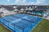Luxurious Single Family Rental Home  featuring modern tennis courts, a sparkling swimming pool, and stylish outdoor seating, surrounded by elegant contemporary homes.