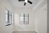 Bright corner space in a modern apartment with large windows and sleek blinds for ample natural light.