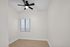 Bright and inviting room with modern ceiling fan and elegant wood flooring, ready for personalization.