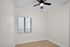 Bright and airy room with sleek wooden flooring, neutral walls, and a modern ceiling fan, perfect for a stylish and cozy living space.