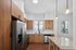 Modern kitchen with sleek stainless steel appliances, elegant wooden cabinetry, and a bright, airy atmosphere.