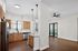Modern open-plan kitchen and living area featuring sleek wood cabinetry, stainless steel appliances, and elegant pendant lighting.