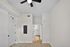 Bright modern room with sleek ceiling fan and light wood flooring, showcasing elegant neutral tones and plenty of natural light.