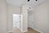 Bright, modern bedroom space with sleek white doors, elegant neutral walls, and warm wood flooring, perfect for a minimalist touch.