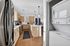 Modern kitchen with sleek stainless-steel appliances, elegant light wood cabinetry, and a convenient in-unit washer and dryer.