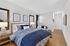Elegant bedroom with stylish blue accents, cozy bedding, and modern decor, offering a tranquil retreat.