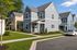 Charming modern apartment complex with stylish gray siding and lush landscaping, featuring paved parking and beautiful residential design.