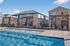 Inviting swimming pool area with elegant wooden pergolas and stylish lounge chairs, perfect for relaxation and luxury living.