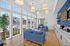 Bright and inviting lounge space with modern blue sofas, elegant lighting, and panoramic windows overlooking a pool area.