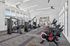 Modern fitness center with state-of-the-art gym equipment, bright natural lighting, and sleek design for an optimal workout experience.