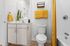 Bright and modern bathroom featuring sleek cabinetry, vibrant yellow accents, and contemporary fixtures.