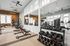 State-of-the-art gym featuring modern exercise equipment, free weights, and sleek design with large windows for natural light.