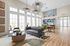 Elegant living area with a plush sofa, stylish pendant lights, and expansive windows offering abundant natural light.