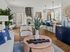 Modern living area with stylish decor featuring a cozy lounge space, sleek kitchen with breakfast bar, elegant dining table, and contemporary art accents.