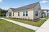 Charming single-story yellow house with large windows and a well-maintained lawn, situated in a serene neighborhood, perfect for family living.