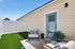 Charming patio with cozy seating and vibrant green artificial grass, perfect for relaxation and outdoor enjoyment.