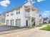 Charming duplex featuring modern architecture with private garages, stylish exterior staircases, and a well-maintained landscaped pathway.