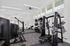Modern apartment gym with top-notch equipment, bright natural lighting, and sleek design for an invigorating workout experience.