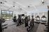 Modern fitness center with state-of-the-art equipment, large windows, and a serene outdoor view, perfect for a revitalizing workout.