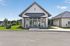 Charming single-story property with a modern design, picturesque lawn, and large windows inviting ample natural light.