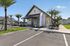 Inviting leasing office exterior with charming architecture, surrounded by palm trees and vibrant greenery, highlighting modern apartment amenities.