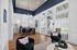 Chic and inviting office space with stylish navy blue chairs, warm hardwood floors, and abundant natural light.