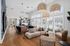 Elegant modern lounge area with natural light, sleek wooden flooring, and stylish woven pendant lights, perfect for relaxation and social gatherings.