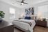 Modern bedroom design with cozy king-sized bed, elegant artwork, and bright natural lighting, perfect for relaxation.