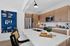 Modern kitchen with sleek appliances, elegant white countertops, warm wooden cabinetry, and stylish decor.