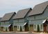 Charming row of carriage houses with wooden accents and lush landscaping.