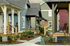 Picturesque street view of colorful single-story homes with inviting porches and vibrant gardens.
