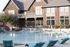 Charming residential building with pool area and modern outdoor lounge chairs.