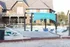 Inviting outdoor pool area with sun loungers, a hammock, and a charming clubhouse in the background.