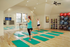 Bright and airy yoga studio with wooden floors, exercise mats, and mirrored walls.