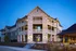 Elegant apartment complex with rustic stone facade and spacious balconies at twilight.
