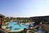 Luxurious outdoor pool area with palm trees and sun loungers in a vibrant apartment community.