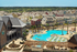 Beautiful aerial view of a residential community with a large swimming pool and sun loungers surrounded by modern homes.