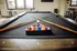 Contemporary game room with a stylish pool table and colorful billiard balls under natural light.