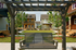 Inviting garden space with a wooden swing surrounded by modern homes and lush greenery.