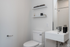 Sleek, modern bathroom showcasing a minimalist design with elegant shelves, chrome fixtures, and a compact sink unit.