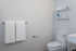 Sleek and modern bathroom with elegant shelving, plush towels, and contemporary fixtures.
