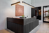Modern and sophisticated reception area with sleek black desk, elegant lighting, and a stylish art piece, exuding a welcoming and luxurious ambiance.