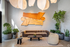 Modern living room with sleek brown sofa, abstract wall art, and lush indoor plants creating a vibrant ambiance.