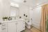Elegant, modern bathroom featuring sleek cabinetry, stylish fixtures, and decorative plants for a fresh ambiance.