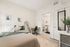Bright and modern bedroom with a cozy bed, stylish desk area, and an ensuite bathroom featuring contemporary decor.