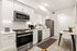 Elegant kitchen space with modern stainless steel appliances, sleek white cabinetry, and cozy dining area.