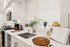Sleek modern kitchen with white cabinetry, stainless steel appliances, and elegant plants adding a touch of nature.