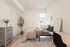 Bright and cozy bedroom with modern decor, featuring a comfortable bed, stylish dresser, and elegant greenery.